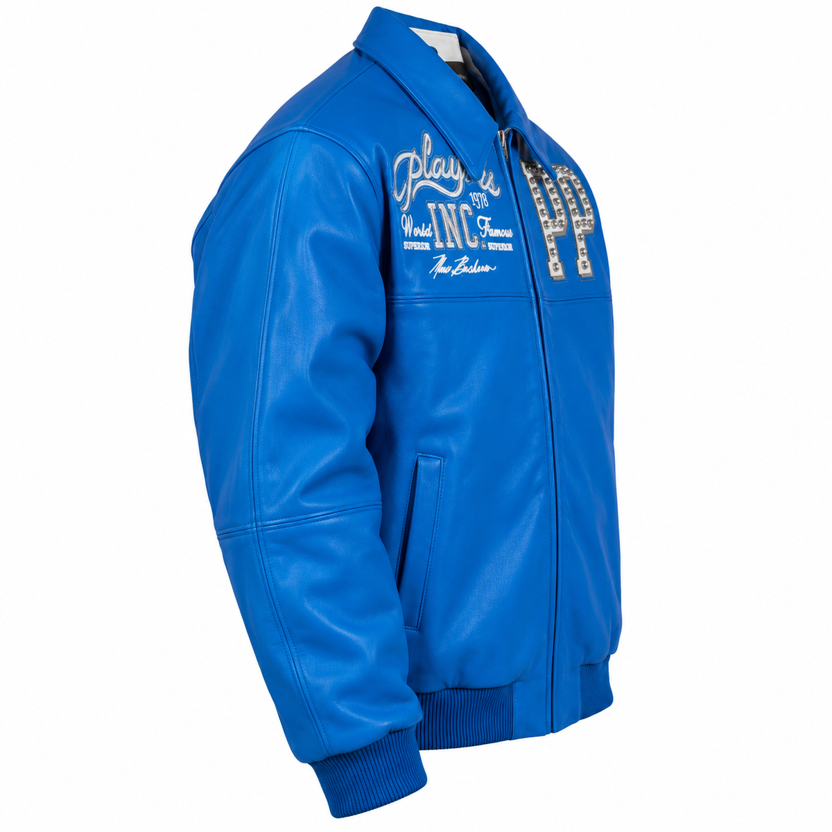 Side view of a royal blue streetwear jacket featuring silver embroidered graphics, studded detailing, ribbed cuffs, and a structured leather-style finish on a white background.