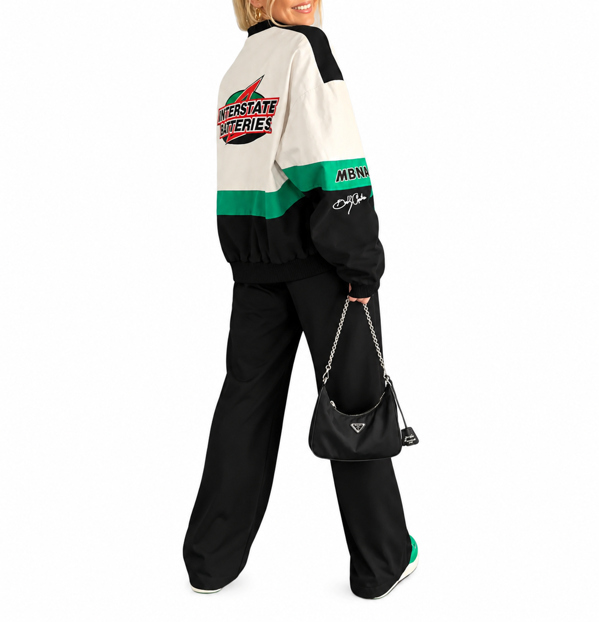 Woman modeling a black, green, and white vintage racing jacket with retro motorsport graphics and casual streetwear styling.